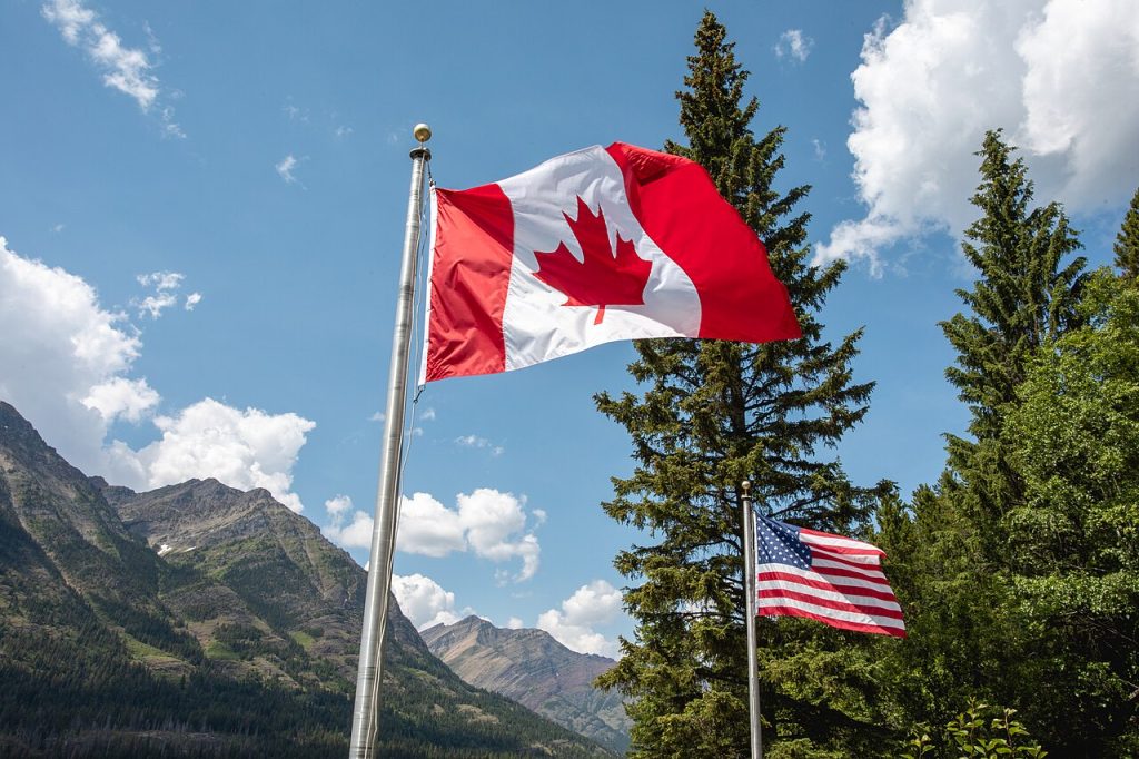 Illustrative archive photograph of Canadian and American flags near the Peace Park Pavilion in Glacier National Park, June 27, 2023.